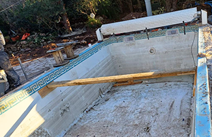 Vidage de la piscine avant rénovation de la coque Photo de la piscine vidée et étayée avant la rénovation de la coque